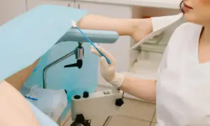 Lekarz wykonuje gbs badanie, pobierając wymaz z szyjki macicy.